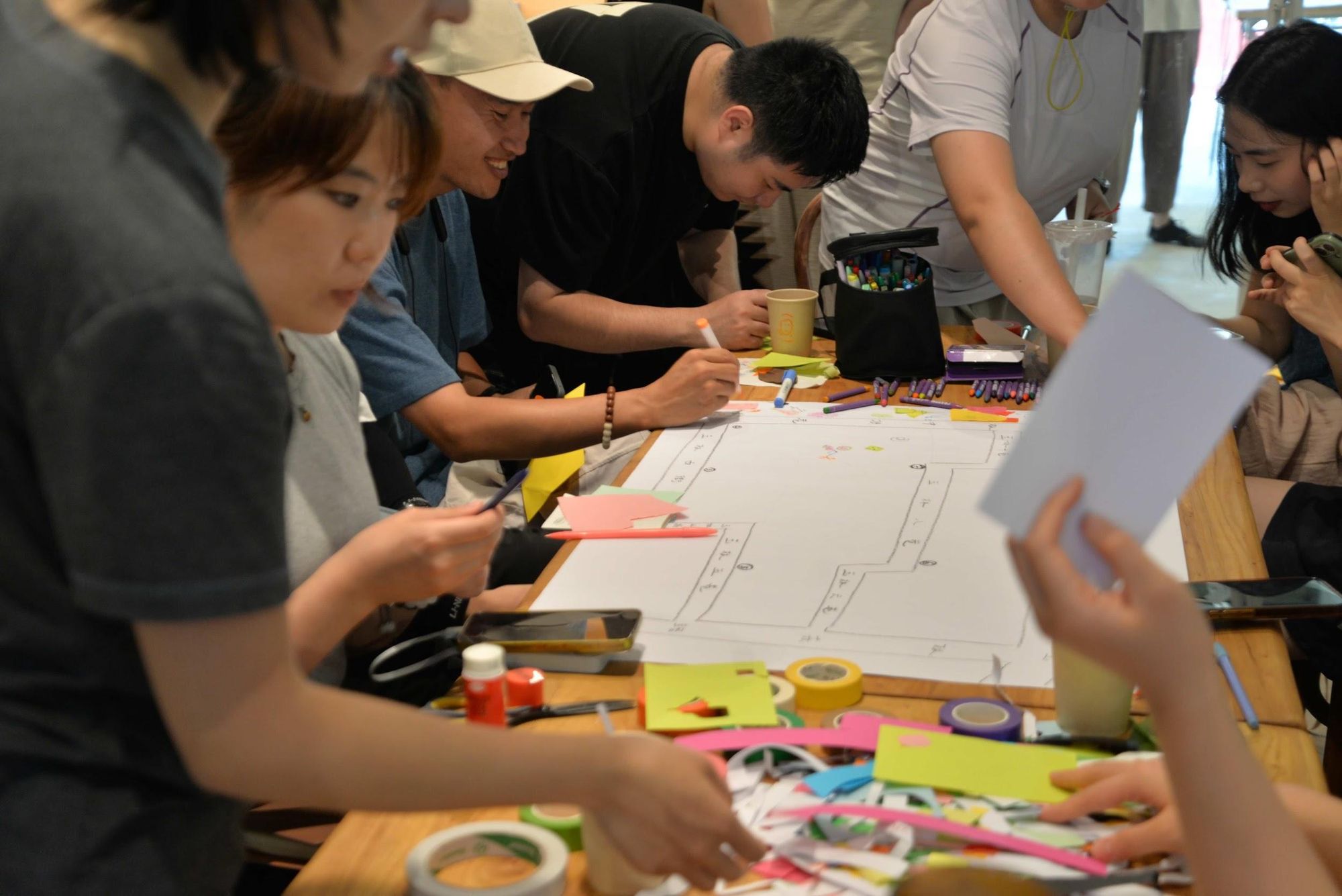Partecipanti al lavoro su un grande foglio durante un workshop